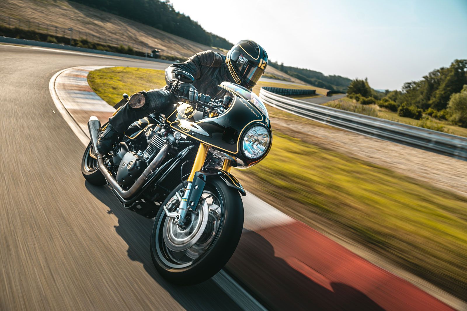 Motorradfahrer in voller Schräglage auf Rennstrecke bei Sonnenschein, sportlich dynamisch aus Nahperspektive fotografiert.